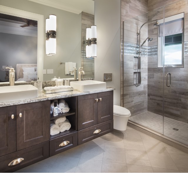 A bathroom with two sinks and a walk in shower