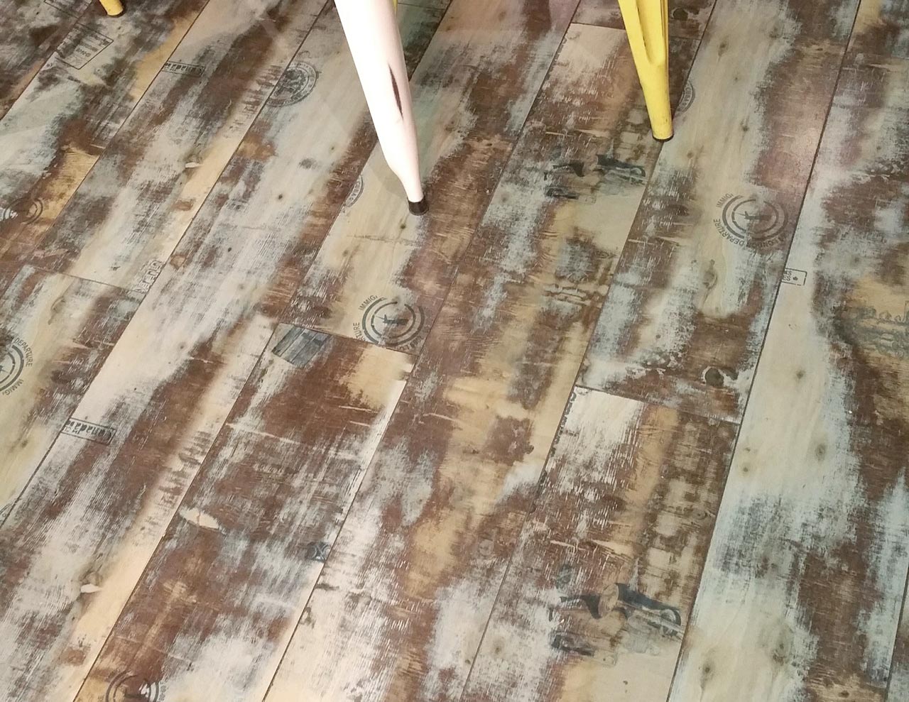 A wooden floor with some brown and white stains