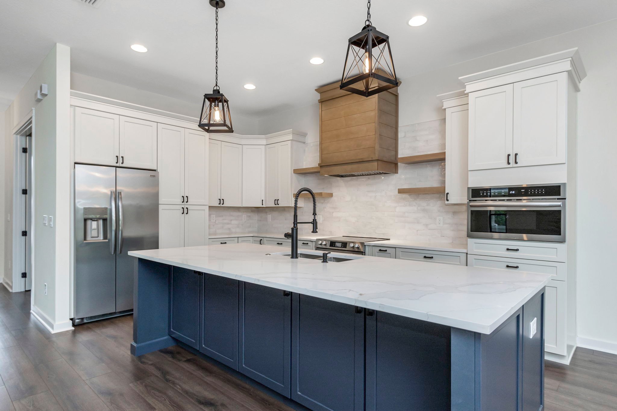 Remodeled kitchen with a blue island and white cabinetry